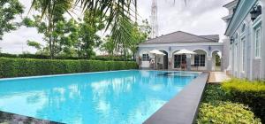 a swimming pool in front of a house at The one CozyHome in Nakhon Ratchasima