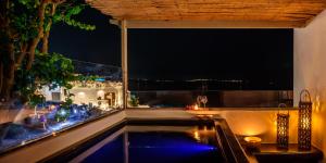 a view of a swimming pool at night at Sensia villa with Hot tub and Caldera View in Oia