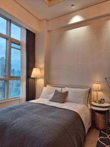 a bedroom with a large bed with a large window at Sunny House in Seoul