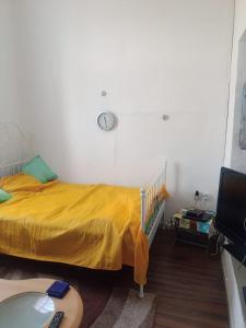 a bedroom with a bed with a clock on the wall at Privatzimmer ohne Komfort im historischen Bahnhof Lalendorf in Lalendorf