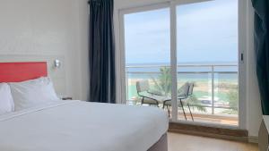 マーフシにあるiCom Marina Sea Viewのベッドと大きな窓があるホテルの部屋