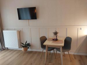 a room with a table and chairs and a television on the wall at Bagry Lake Apartment in Kraków +17 photos