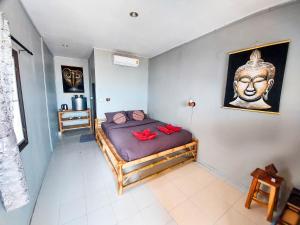 a bedroom with a bed with a statue of a head at Last Hammock Beach Resort in Baan Khai