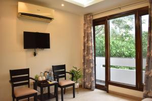 a living room with chairs and a tv and a window at Two Green Park in New Delhi