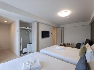 a hotel room with two beds and a tv at ESLEAD HOTEL Osaka Nipponbashi in Osaka