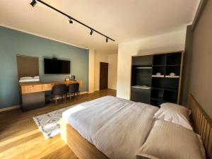 a bedroom with a bed and a desk and a television at Grand Apartments Prishtina in Pristina