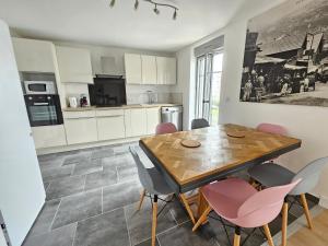 a kitchen and dining room with a wooden table and chairs at Le Charme du Sanctuaire 8 couchages 400m de la Grotte in Lourdes