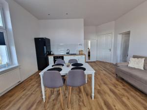 a living room with a table and chairs and a couch at Apartamenty Zakonne "Apartament Wielkiego Mistrza" in Malbork