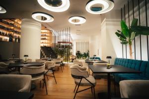 restauracja ze stołami, krzesłami i światłami w obiekcie Amario Suites Hotel w mieście Ejo