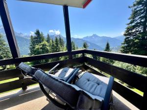 uma cadeira numa varanda com vista para as montanhas em THE ALPINE STUDIO proche du lac Frience, chiens admis, parking privé em Gryon