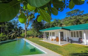 a house with a swimming pool in front of it at Spring Villa Neluwa in Nelluwa