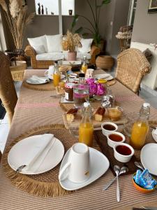 a table with plates of food and drinks on it at Séverine chambres d’hôtes in Floing