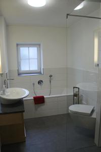 a bathroom with a sink and a toilet and a tub at Villa Hilde in Oy-Mittelberg