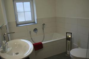 a bathroom with a sink and a tub and a toilet at Villa Hilde in Oy-Mittelberg +7 photos