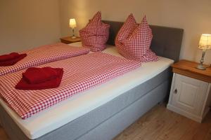 a bed with red and white pillows on it at Villa Hilde in Oy-Mittelberg