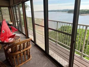 a screened in porch with a view of the water at McArthur Heights Hotel in Miura