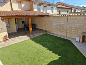 einen Garten mit grünem Gras vor einem Haus in der Unterkunft Casa Rural LA MIELGUERA in Villalcázar de Sirga