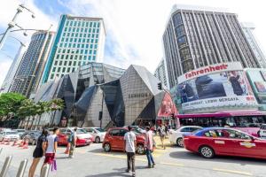 クアラルンプールにあるFahrenheit 88 Suites Bukit Bintang by Roseline 3Rの高層ビルの前に車が停まる賑やかな街道
