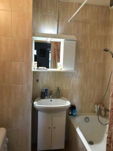 a bathroom with a sink and a mirror and a tub at Rózsadomb apartman in Pécs