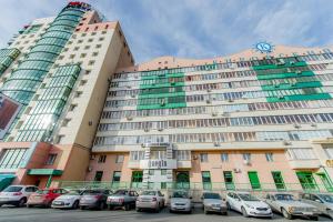 un gran edificio con coches estacionados en un estacionamiento en Five Stars Kirova 23a, en Chelyabinsk