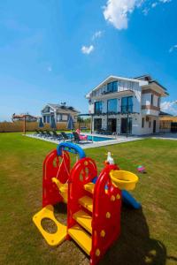 einen Spielplatz in einem Hof vor einem Haus in der Unterkunft Villa Bahar 2 Triplex Luxury New Villa in Fethiye Oludeniz! in Ovacık