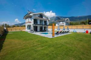 ein Haus mit einem großen Garten mit Pool in der Unterkunft Villa Bahar 2 Triplex Luxury New Villa in Fethiye Oludeniz! in Ovacık