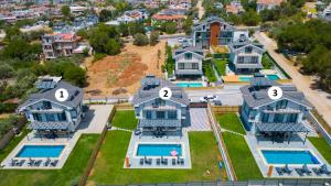 eine Luftaufnahme eines großen Hauses mit sechs Nummern in der Unterkunft Villa Bahar 2 Triplex Luxury New Villa in Fethiye Oludeniz! in Ovacık