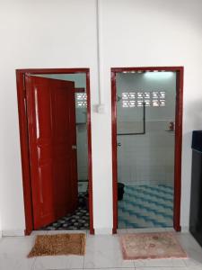 a red door leading to a bathroom with a shower at Roomstay Mok House - Unit 2 in Kuala Terengganu