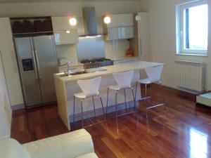 a kitchen with a counter and stools in a room at Apartments Villa Ina in Brseč