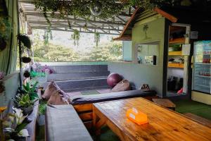 a living room with a wooden table and a bench at Kokos Hostel Padang City in Padang