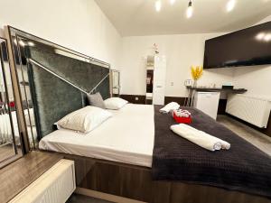 a bedroom with a large bed with two towels on it at Elixir Central Studio with Balcony & Panoramic View in Craiova