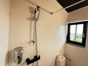 a shower in a bathroom with a toilet and a window at Elixir Central Studio with Balcony & Panoramic View in Craiova