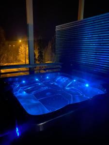 a jacuzzi tub with blue lights in a room at Pärjä Suites 2 in Syöte