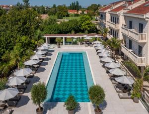an overhead view of a swimming pool with chairs and umbrellas at Hotel President Solin in Solin