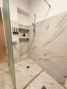 Un baño con ducha con puerta de cristal. en Anna Lux Studio, en Craiova