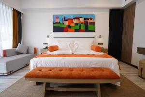 JalpāiguriPaciano的一间卧室配有一张带橙色长凳的大床