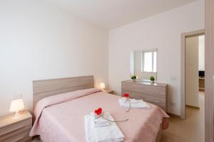 a bedroom with a bed with two towels and a mirror at Suite Ondina Viareggio Apartments in Viareggio