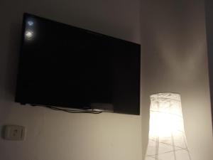 a flat screen tv hanging on a wall with a lamp at Pisa Center in Pisa