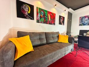 クラヨーヴァにあるCourtyard Central Premium Apartmentのリビングルーム(ブラウンソファ、黄色い枕付)