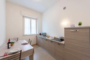 a kitchen with a counter and a sink and a table at Suite Ondina Viareggio Apartments in Viareggio