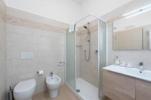 a bathroom with a shower and a toilet and a sink at Suite Ondina Viareggio Apartments in Viareggio +77 photos