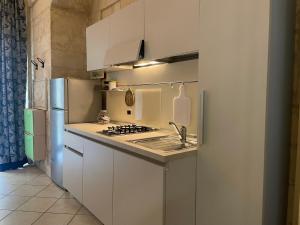 een witte keuken met een wastafel en een koelkast bij Casa Fortunato Corte Adorni in Lecce +12 foto's