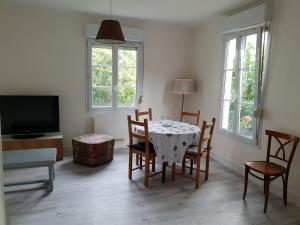 a living room with a table with chairs and a tv at Maison à Issy les Moulineaux, proche de Paris in Issy-les-Moulineaux
