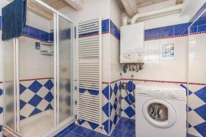 Un baño con paredes de azulejos azules y blancos y una lavadora. en Casa Alessandra, en Falcade 88 fotos más