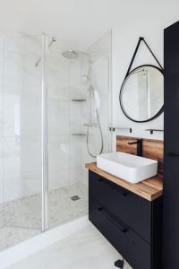 une salle de bain avec un lavabo et une douche avec un miroir dans l'établissement Évasion Toscane Val d'Europe - Proche Disneyland, à Serris