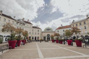 une cour avec un bouquet de plantes et de bâtiments dans l'établissement Évasion Toscane Val d'Europe - Proche Disneyland, à Serris