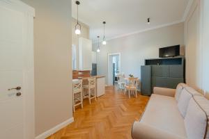 a living room with a couch and a kitchen at Old Town Square Apartments Cluj in Cluj-Napoca