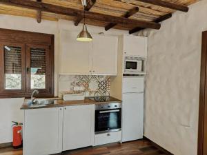 a kitchen with white cabinets and a stove top oven at Elegant Villa with Jacuzzi in Canillas de Albaida in Canillas de Albaida