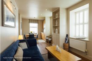 a living room with a blue couch and a table at St Brides Spa Hotel & Village Apartments in Saundersfoot