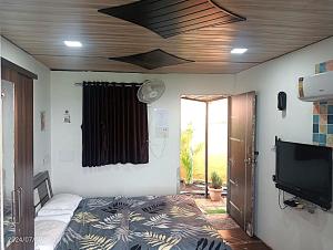 a bedroom with a bed and a tv and a ceiling at Western Valley Cottages , Panchagani in Panchgani